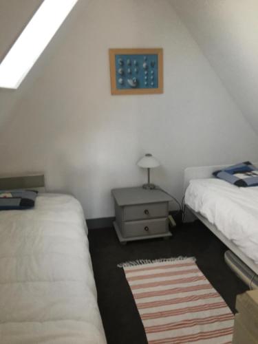 Zimmer im Dachgeschoss mit 2 Betten und einem Tisch mit einer Lampe in der Unterkunft Cocon sur mer in Varengeville-sur-Mer
