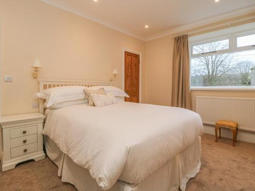 a bedroom with a large white bed and a window at Westholme in Barnard Castle
