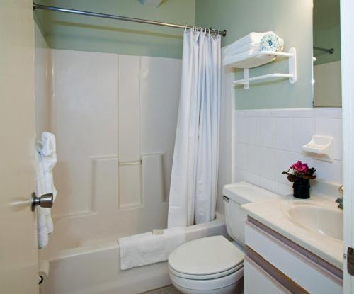 a white bathroom with a toilet and a sink at Lotus Inn in Wildwood Crest