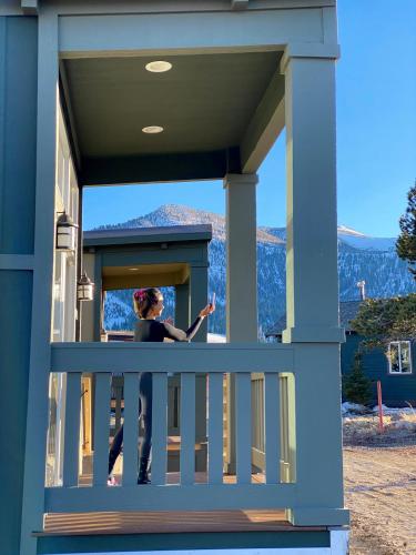 a woman standing on the balcony of a house at Sierra Meadows Ranch in Mammoth Lakes