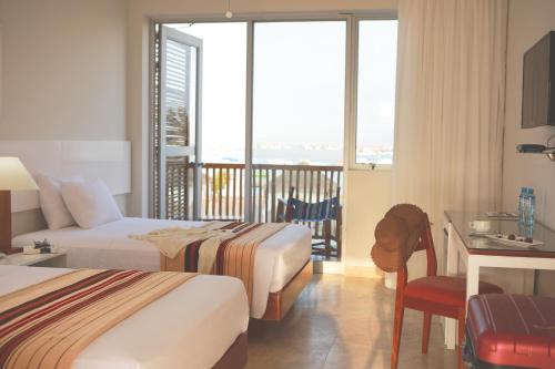 a hotel room with two beds and a balcony at San Agustin Paracas in Paracas