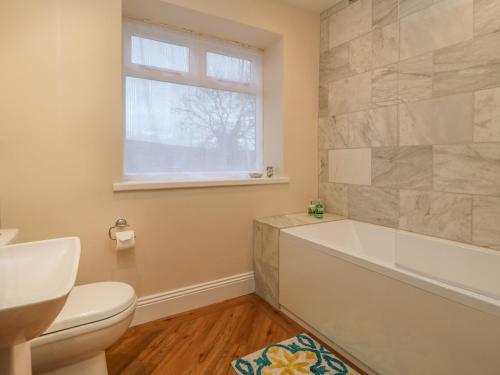 a bathroom with a tub and a toilet and a window at Westholme in Barnard Castle