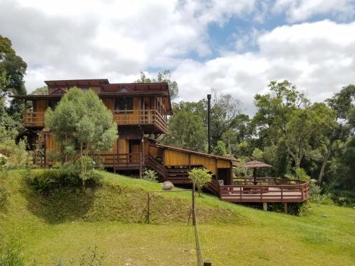 una casa de madera en la cima de una colina en Holo Pousada Vale Encantado, en Rancho Queimado