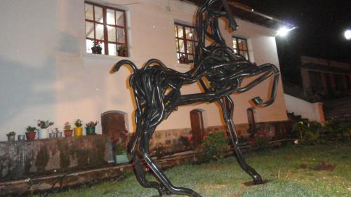 uma estátua de metal de um cavalo em frente a uma casa em Villa Victoria em Machachi