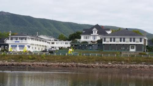 a group of white houses next to a body of water at Hôtel Aquamer in Carleton sur Mer