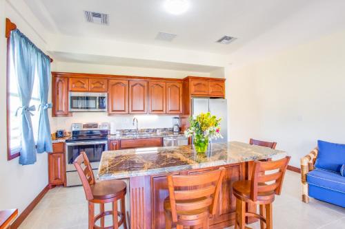 a kitchen with wooden cabinets and a island with chairs at Seiri del Mar in Hopkins