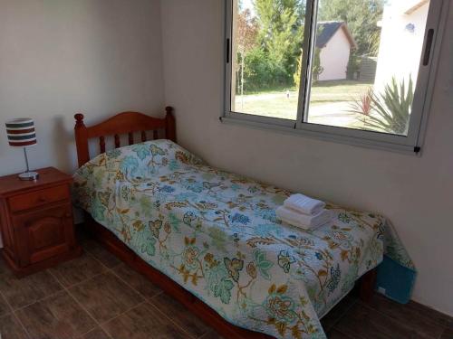 a small bedroom with a bed and a window at Cabañas Elabu in San Miguel del Monte
