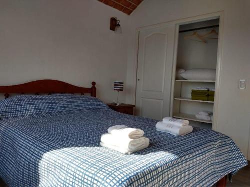 a bedroom with a bed with towels on it at Cabañas Elabu in San Miguel del Monte