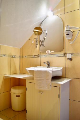 a bathroom with a sink and a mirror at IWONA Pokoje Apartamenty in Karwia