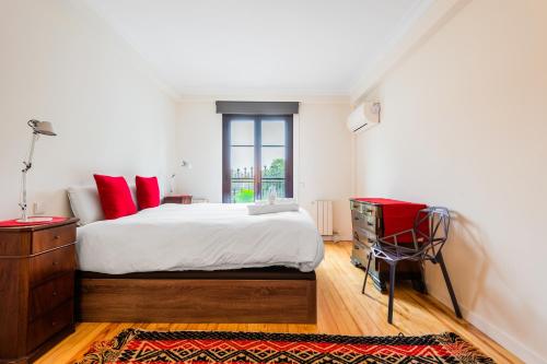een slaapkamer met een bed met rode kussens en een raam bij Minty Stay 1BD -El Retiro in Madrid