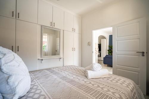 a white bedroom with a bed and a door at M8 Umdloti Holiday Resort in Umdloti