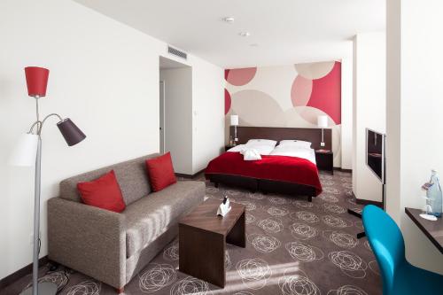 een woonkamer met een bank en een bed bij Webers - Das Hotel im Ruhrturm, Stefan Weber GmbH in Essen