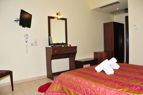a bedroom with a bed and a dresser and a mirror at Hotel Gogos in Kalabaka