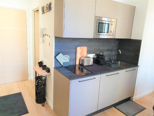 eine Küche mit einer Spüle und einer Mikrowelle in der Unterkunft HYPERCENTRE/LAMARTINE APPART 211 in Nizza