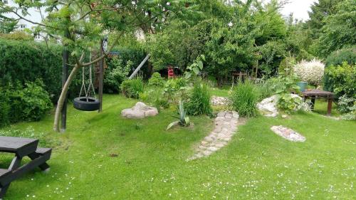 a garden with a swing in the grass at Zimmervermietung Koltermann in Greifswald