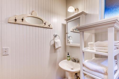 ein weißes Badezimmer mit Waschbecken und Toilette in der Unterkunft Woodland Cottage by the Sea in Yachats