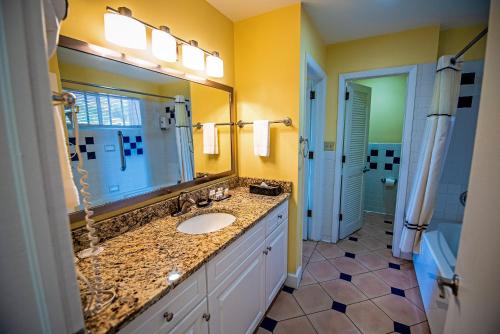 a bathroom with a sink and a large mirror at Pirate's Pension at Bluebeard's Castle by Capital Vacations in Pearson Gardens