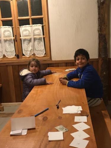 two young children sitting at a wooden table at Parque la Pajarera in Puerto Varas