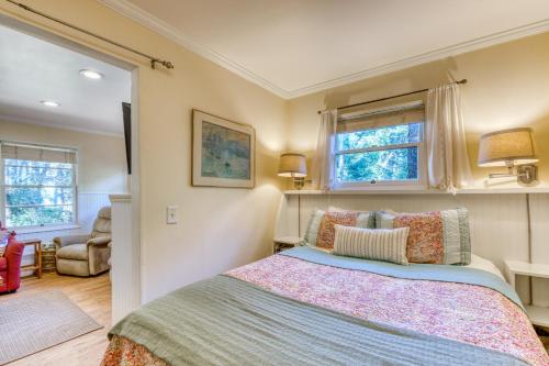 ein Schlafzimmer mit einem Bett und zwei Fenstern in der Unterkunft Woodland Cottage by the Sea in Yachats