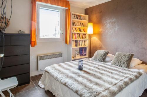 1 dormitorio con cama, ventana y estante para libros en Charming and calm flat with balcony and parking in Trouville - Welkeys, en Trouville-sur-Mer