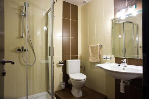 y baño con aseo, lavabo y ducha. en Penzion Kastiel, en Veľký Krtíš