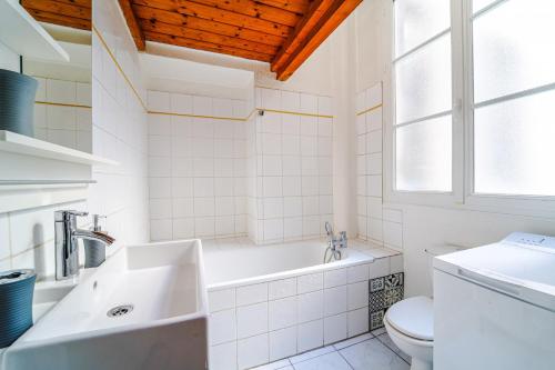 ein Badezimmer mit einer Badewanne, einem WC und einem Waschbecken in der Unterkunft DIFY Petit Prince - Place Bellecour in Lyon