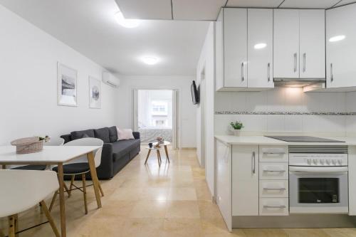 a kitchen and living room with a couch and a table at Apartamentos Aurea in Benidorm