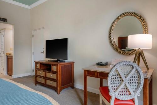 a bedroom with a desk with a tv and a mirror at Omni Amelia Island Resort in Amelia Island