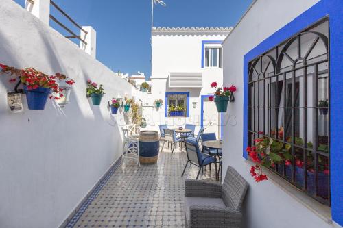 a walkway with chairs and tables and flowers on a building at Casa San Miguel in Estepona