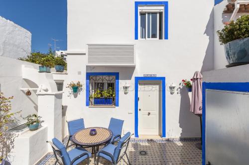 a patio with a table and chairs in front of a white building at Casa San Miguel in Estepona
