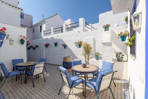 a patio with tables and chairs on a building at Casa San Miguel in Estepona