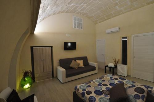 a living room with a bed and a couch at Le dimore della Luna in Matera