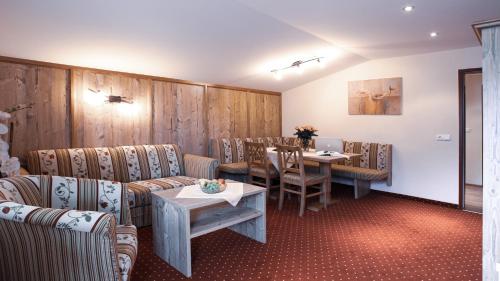 a waiting room with chairs and a table with a laptop at Panorama Appartements in Längenfeld