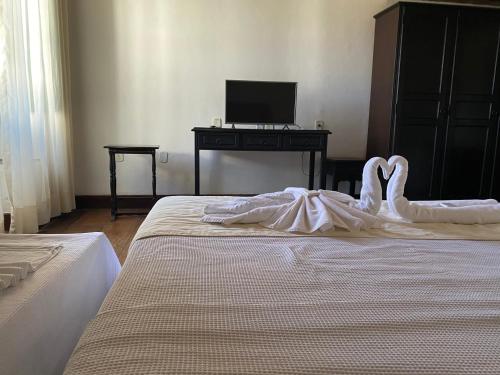 a bedroom with two beds and a desk with a computer at Pousada Convento do Carmo in Cachoeira