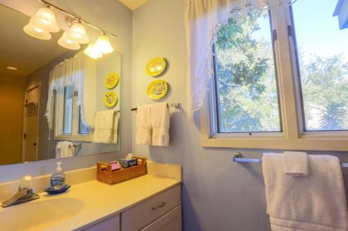 a bathroom with a sink and a mirror and a window at Flip Flop Inn in Isle of Palms