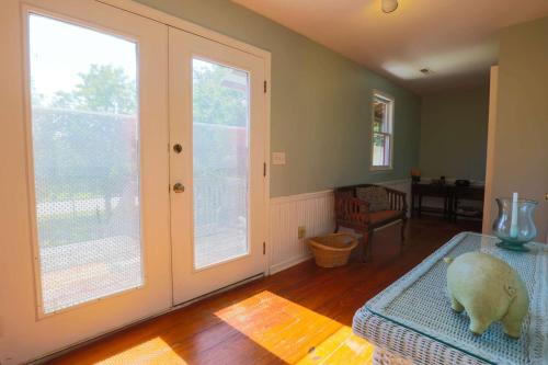 a living room with a large window and a statue of a sheep on a table at Decked Out in Sullivans Island