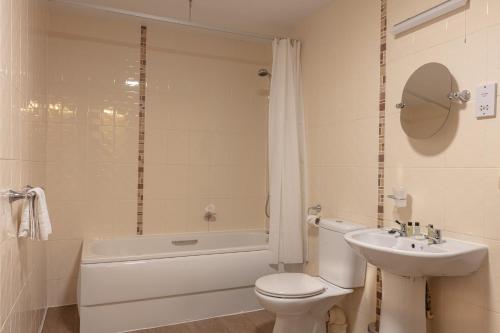 a white bathroom with a toilet and a sink at The New Inn by Roomsbooked in Gloucester