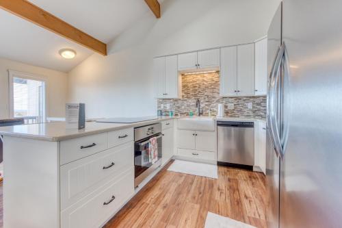 a kitchen with white cabinets and a refrigerator at Coastal Comfort in Oceanside