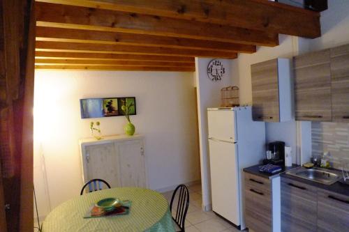 a kitchen with a table and a white refrigerator at gite des deux rivières in Nant