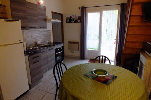 a kitchen with a table and a kitchen with a refrigerator at gite des deux rivières in Nant