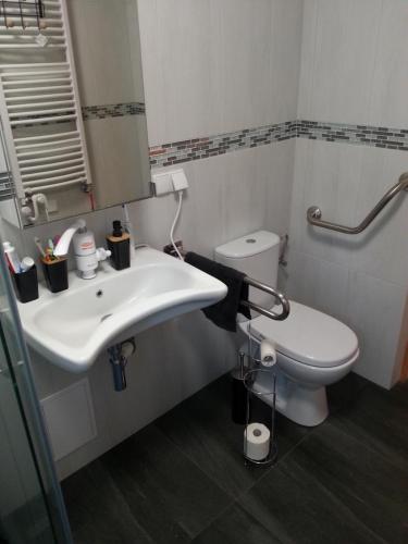 a bathroom with a white sink and a toilet at Biały Żagiel - Dom do wynajęcia Pluski in Pluski