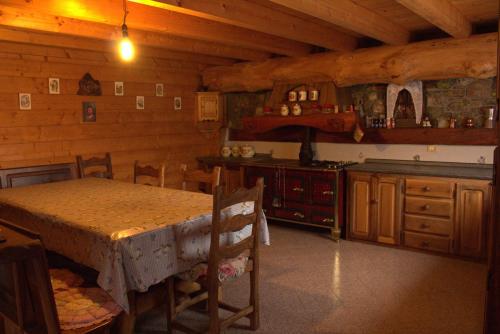 una cucina con tavolo e bancone in una cabina di CHALET MONT AVIC a Champdepraz