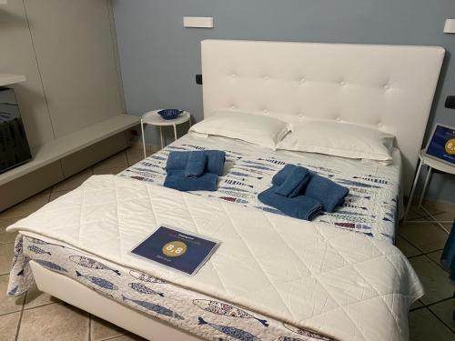 ein großes weißes Bett mit zwei blauen Kissen darauf in der Unterkunft B&B ALDA in Levanto