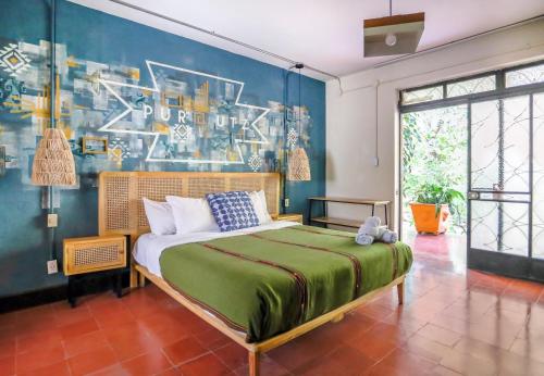 ein Schlafzimmer mit einem Bett und einer blauen Wand in der Unterkunft Socialtel Atitlan in Panajachel