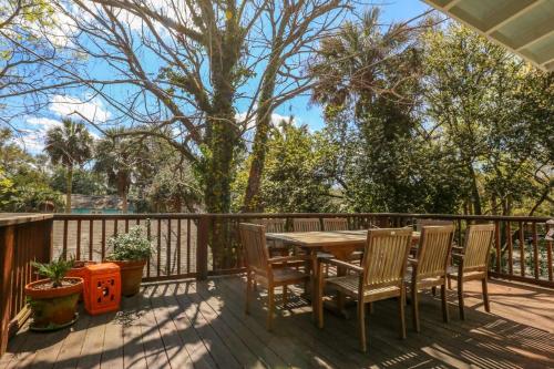 a wooden deck with a wooden table and chairs at Shell Station House in Folly Beach