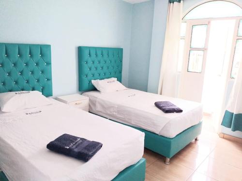 2 camas en una habitación de color azul y blanco en Hospedaje La Ola Azul en Puerto Chicama