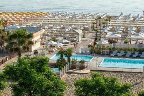 una vista aérea de un complejo con piscina y sombrillas en Riccione Beach Hotel - Enjoy your Summer -Beach Village incluso, en Riccione