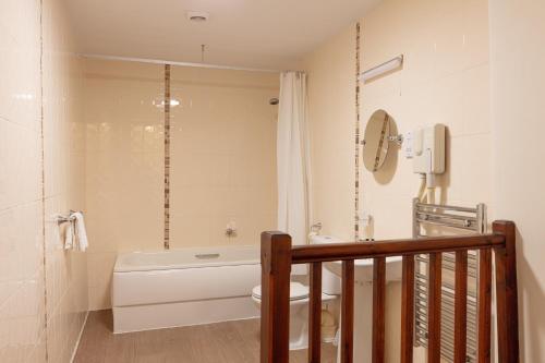 a bathroom with a tub and a toilet and a shower at The New Inn by Roomsbooked in Gloucester