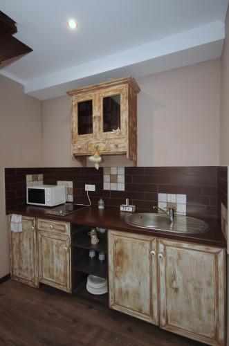 a kitchen with a sink and a microwave at Guest House Romantika Panzio in Gyula