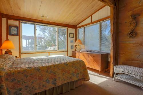 um quarto com uma cama, uma secretária e janelas em Someplace Else em Folly Beach